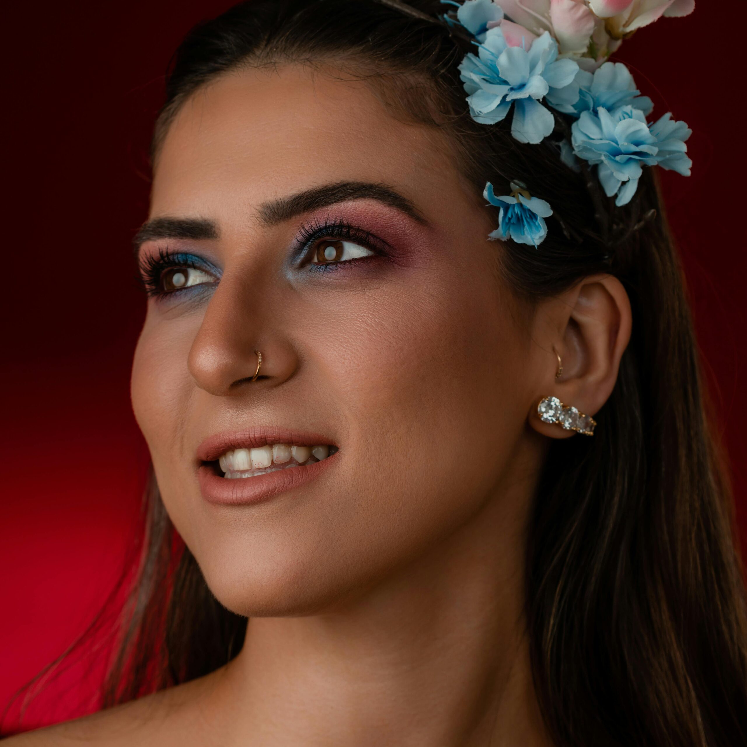 Close-up portrait of a woman with vibrant makeup and floral headpiece.